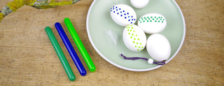 buntes Wachs für sorbische Ostereier, Sets mit 3 Wachsstangen aus Bienenwachs in den Farben grün, dunkelblau und maigrün, auf einem Teller befinden sich 3 bemalte Eier